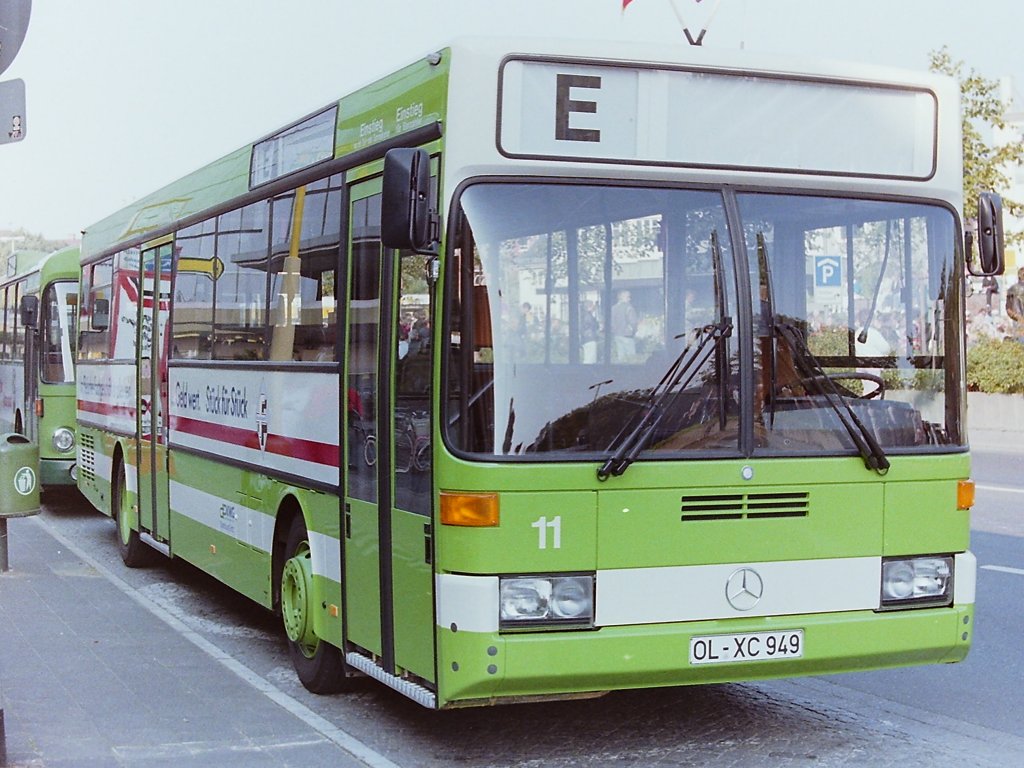 Wagen 11, OL-XC 949, EZ: 02.09.1987. Die neue Generation von Linienbussen erreichte Oldenburg p�nktlich zum Kramermarkt im September 1987. Wagen 11, ein Daimler Benz O 405, war der erste Bus des neuen Standardlininenbus Typ II f�r die VWG. Erst wenige Monate vorher waren die Setra mit den Wagen 11 bis 18 ausgeschieden. Als die Fahrzeuge 1976 angeschafft wurden, waren es nicht nur andere als die gewohnten Busse des Typ SL I, Pekol begann damals auch die Fahrzeuge wieder neu zu nummerieren und man f�hrte einen neuen Farbton ein. Jetzt, 11 Jahre sp�ter, begann die Benummerung wieder bei der 11, es gab wieder einen neuen Bustyp und wieder eine neue Farbe. Und eine weitere alte Tradition wurde wieder eingef�hrt : Die Busse wurden zum Kramermarkt wieder beflaggt. Das Foto zeigt Wagen 11 am 26.09.87, dem offiziellen Kramermarktbeginn, am Stadtmuseum West.