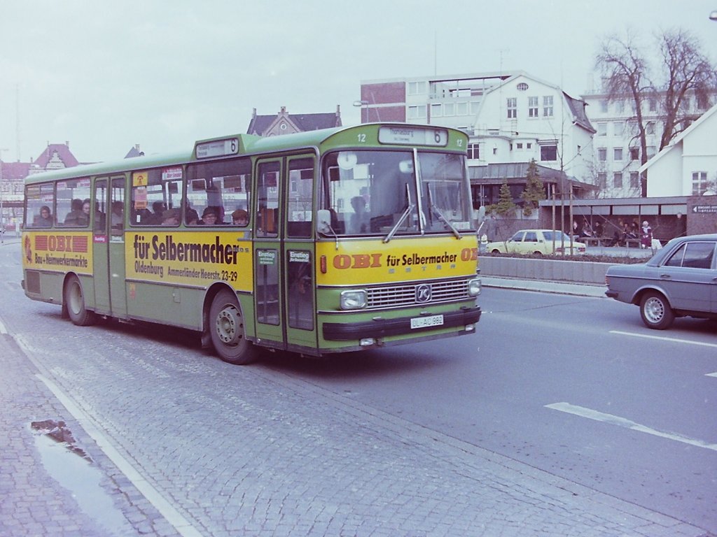 Wagen 12, OL-AC 982, EZ: 1976. Das bereits ver�ffentlichte Foto von Wagen 12, l�sst leider nicht so viel von der Werbung erkennen, daher hier noch eine weitere Aufnahme. Der Bus verl�sst am 30.03.83 auf der Linie 6, die Haltestelle Stadtmuseum West in Fahrtrichtung Thomasburg. Auf diesem Bild ist auch sehr gut zu sehen, wie tief die Fahrg�ste im vorderen Teil dieses Bustyp gesessen haben. Da auf einen Kofferraum verzichtet werden konnte, lag der Boden im vorderen Teil wesentlich tiefer als bei den Reisebussen, auf deren Fahrgestell dieser Linienbus basierte. Die Fahrg�ste konnten, je nach eigener K�rpergr��e, teilweise gerade mal aus den Fenster sehen.