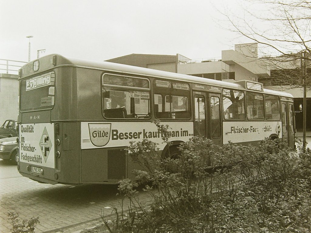 Wagen 19, OL-NC 519, EZ: 1977. Hier noch einmal der erste MAN SL 200 mit neuem dunkleren Gr�n und jetzt mit  NC  im Kennzeichen. Die Aufnahme zeigt den Bus, leider nur in s/w, im Mai 1982 im Bundesbahnweg mit seiner urspr�nglichen Version der FLEISCHER GILDE-Werbung. Diese war, wie hier deutlich zu sehen ist, bereits stark verschliessen und h�tte bald erneuert werden m�ssen.