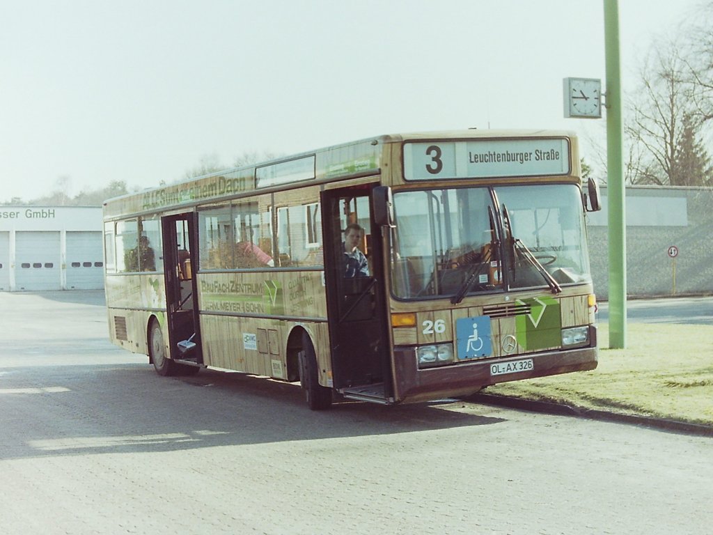 Wagen 26. ... als der Bus pl�tzlich nach rechts auf das Betriebsgel�nde abbog und der Fahrer den Wagen in der Ausfahrt parkte. �hnlich verdutzt waren wohl auch einige der Fahrg�ste, die noch an Bord waren. Den Grund f�r den ausserplanm��igen Halt konnte ich nicht in Erfahrung bringen, auch nicht warum beide T�ren g�ffnet sind. Oder doch : Wer genau hinsieht erkennt im hinteren Eingang das untere Ende eines Schrubbers und ablaufendes Sp�lwasser. Da wird der Fahrer wohl die Reste eines Mal�rs entfernt haben und damit diese Reste besser ablaufen hat er den Bus auf den Bordstein gestellt. Man muss sich halt zu helfen wissen. Auf jeden Fall gelang mir ein seltenes Foto auf dem im �brigen sehr sch�n das Hinweisschild f�r den Rollstuhlfahrer-Hublift zu sehen ist.