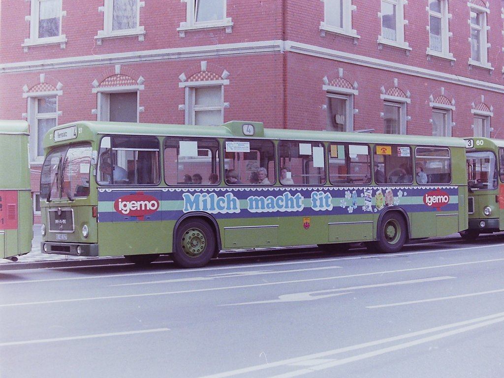 Wagen 27, OL-NC 527, EZ: 1978. Sp�ter als Wagen 163, aber p�nktlich zum Oldenburger Kramermarkt kamen sieben weitere MAN SL 200 nach Oldenburg. Diesmal waren die Wagennummern aber nicht mehr in bla�wei�en, gr�n hinterlegten schmalen Ziffern, sondern in hellen fetten Zahlen aufgebracht. Die Aufnahme zeigt Wagen 27 am 29.04.84 an der Hauptumsteigestelle LAPPAN NORD. Der Bus fuhr mit dieser Werbung unver�ndert bis zu seinem Ausscheiden 1988.